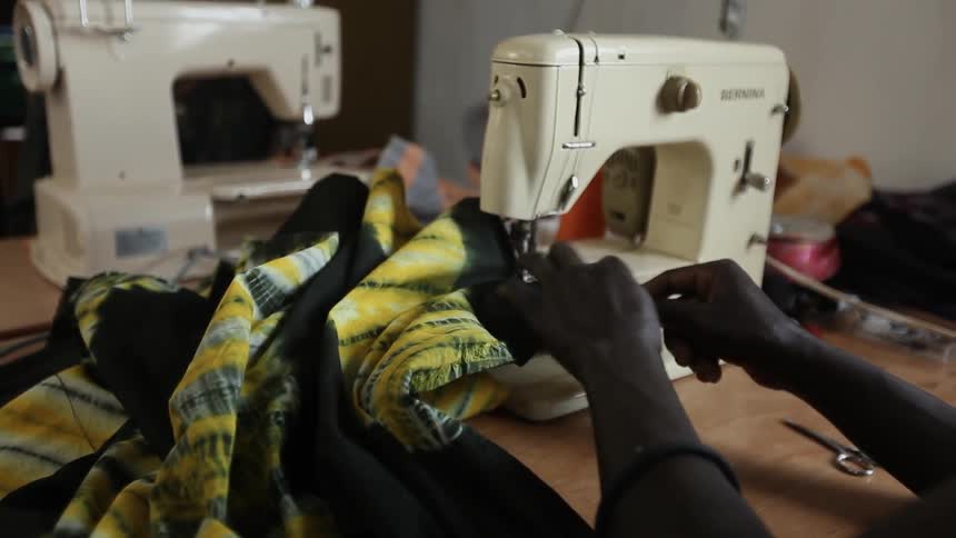 A worker sews a piece of fabric