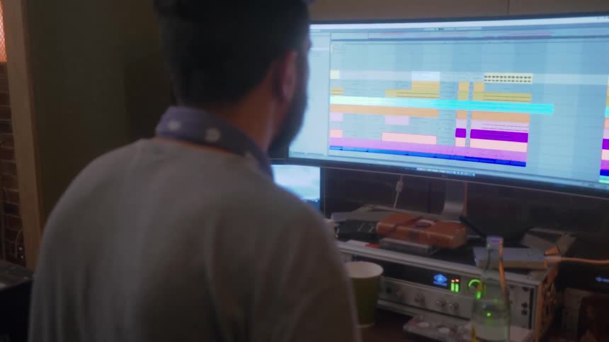 Man sits at desk making electronic music