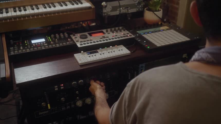 A man is sitting in his studio and making music