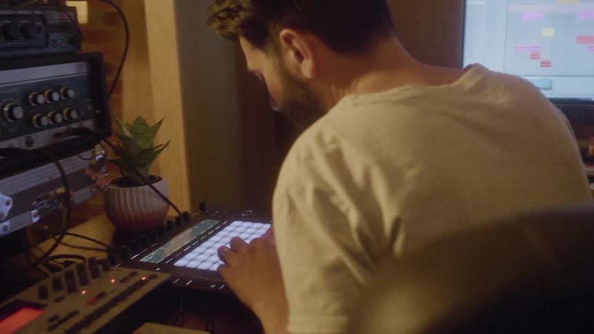 Man sits at desk making electronic music