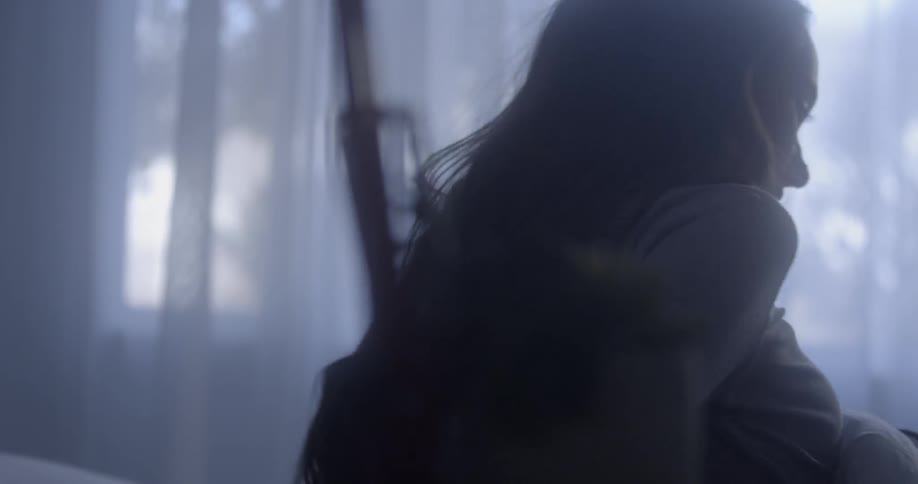 A woman wakes and sits up in bed