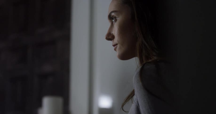 A woman looks down in the home