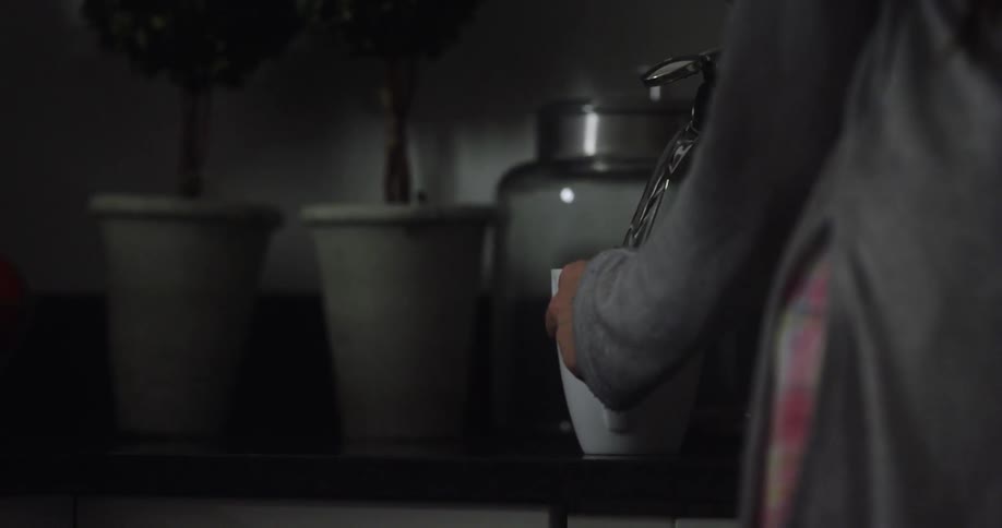 Woman pours hot water from a teapot into a mug