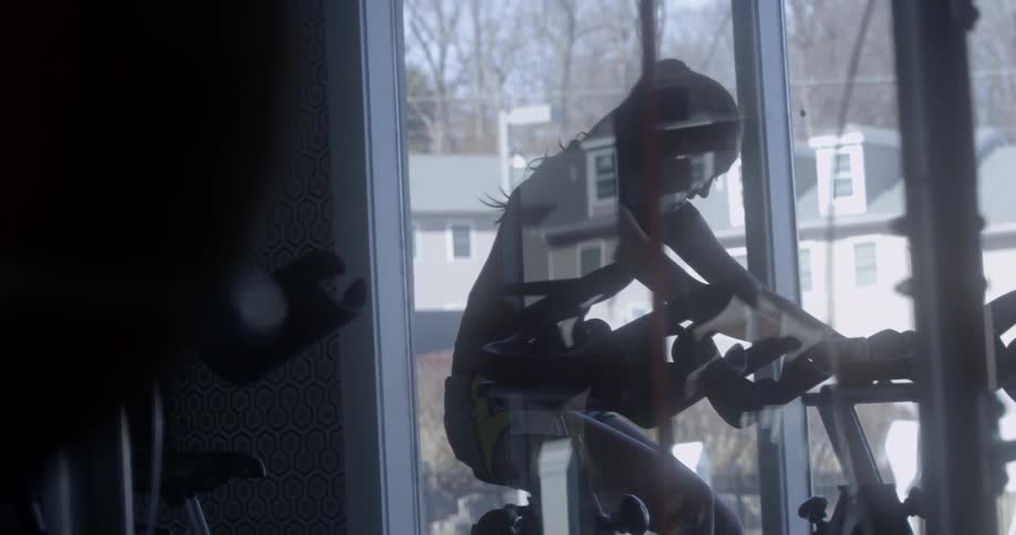 A woman is on the exercise bike at the gym