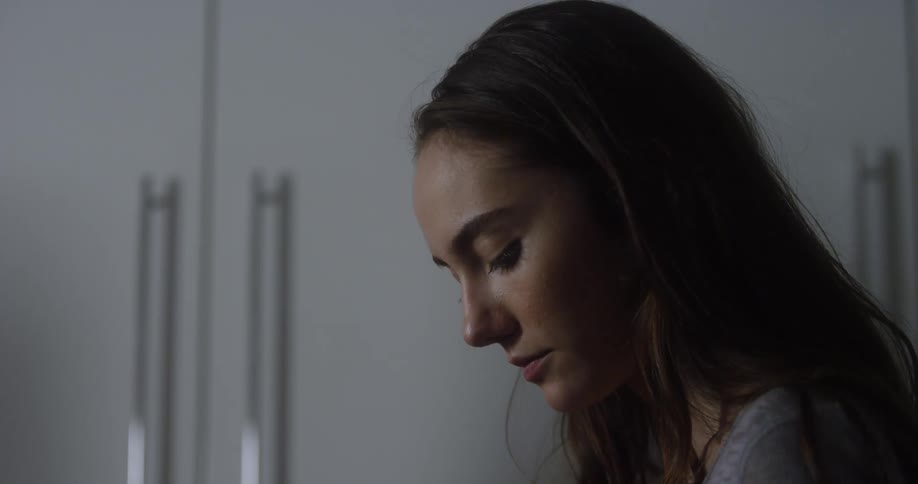 A woman looks around and blinks