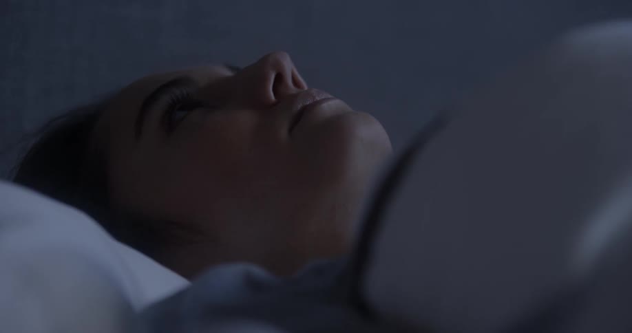 A woman is resting in her bed