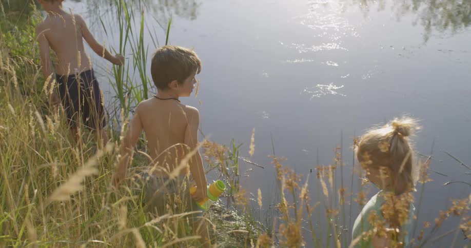 Kids walk along the edge of a lake