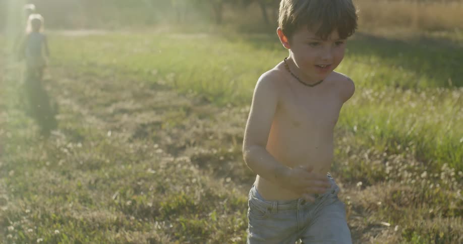 Children run across a grassy field