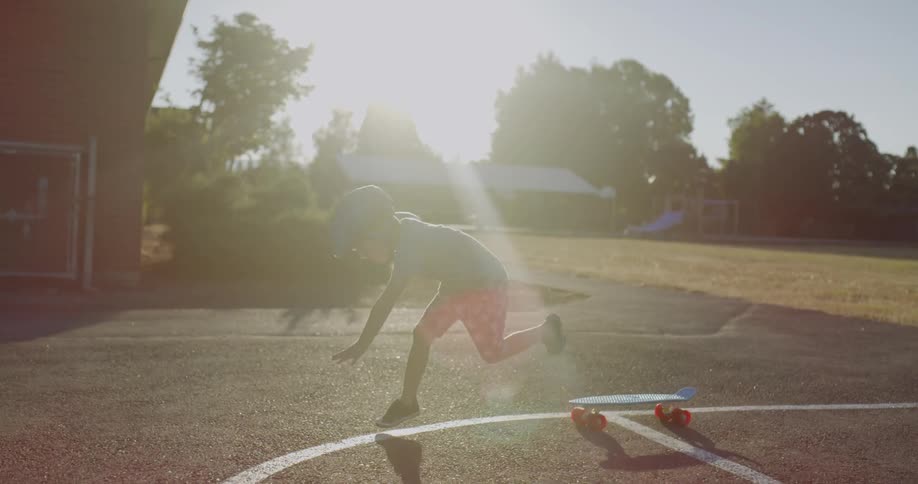 Young child pushes a skateboard and falls