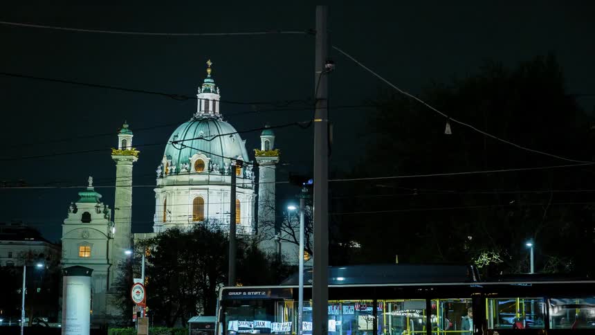 Pedestrians and trains travel in a city at night