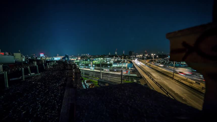 Cars drive on a city road at night