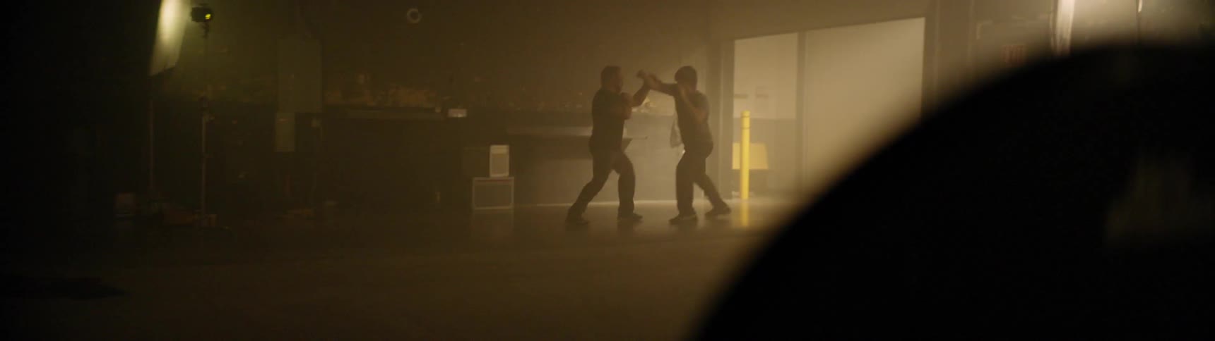 Two men are kickboxing in the gym
