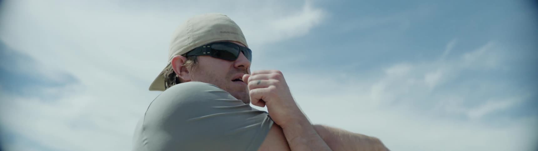 A man stretches his arms outside in a rural area