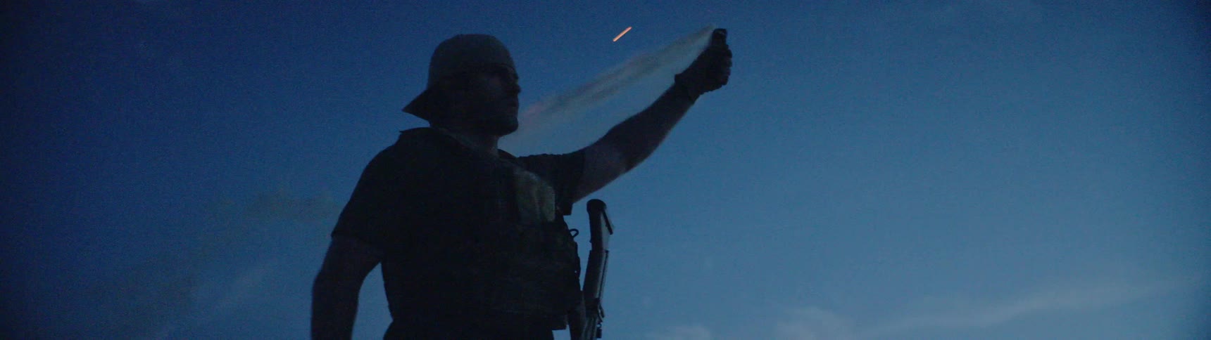 A man lights a flare and raises it towards the sky