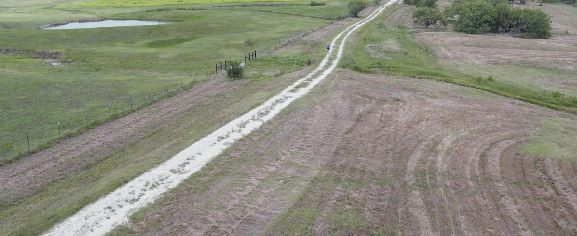 A jogger runs on a rural dirt road
