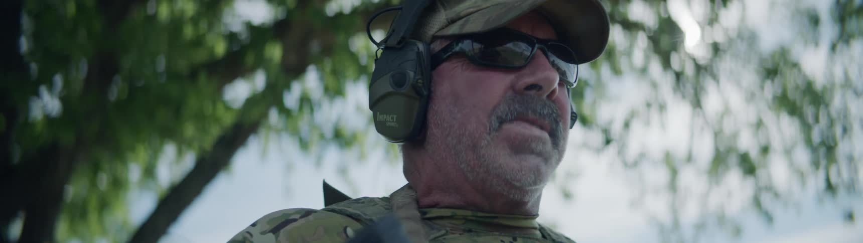 Man holds machine gun and scans the area