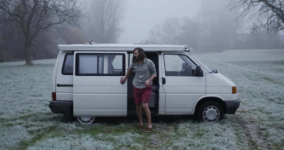 A man exits a white van in the snow