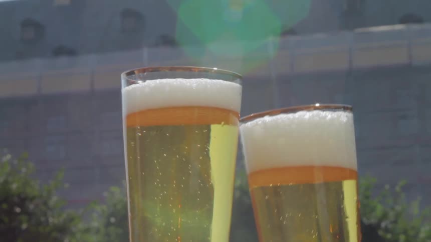 Two people celebrate with alcohol on a garden patio