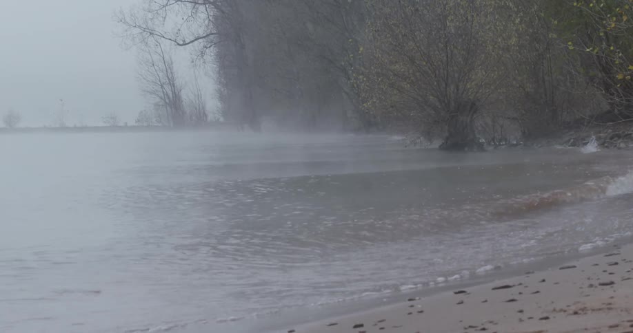 Water flows onto the shore on a foggy day