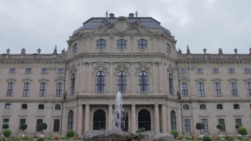 A fountain flows in front of a stone building