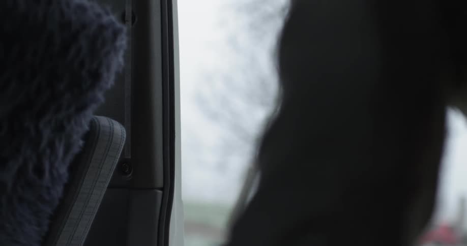 A man opens the side door of a van
