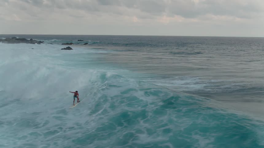 A surfer rides a large wave
