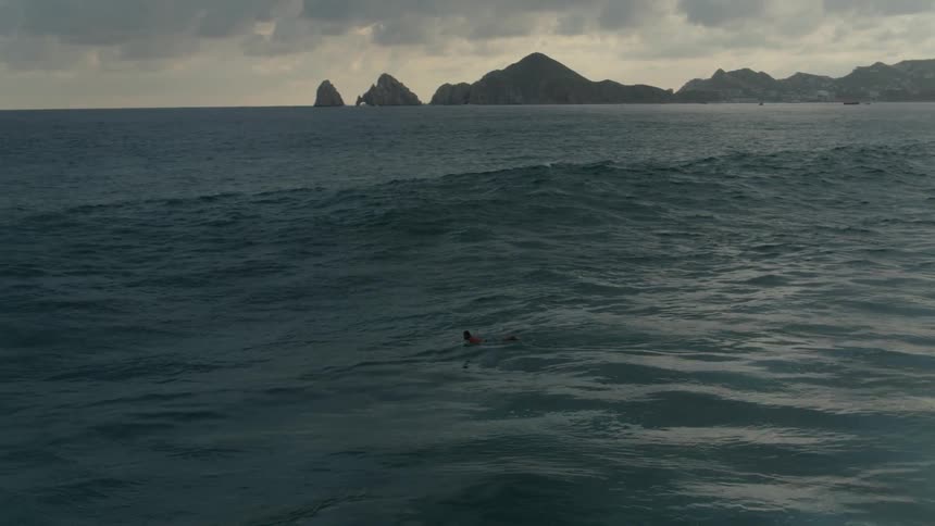 A person swims out to the ocean