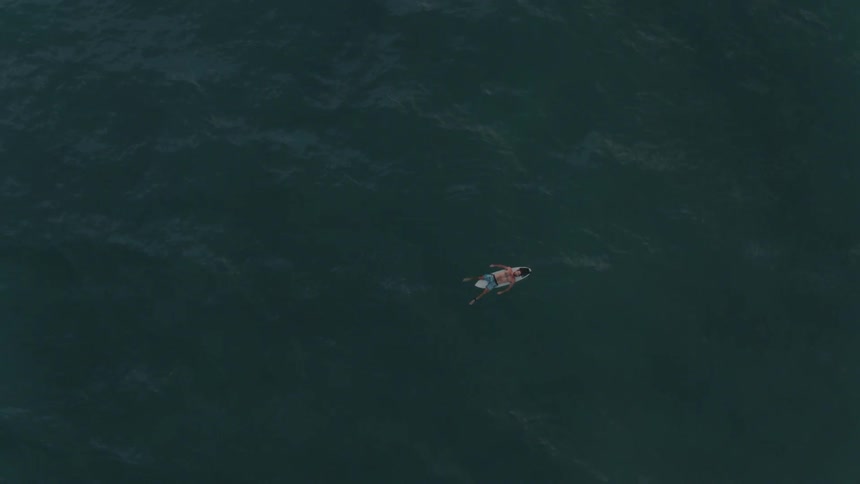 A person floats on a surfboard