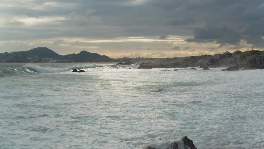 Waves coming ashore on a beach on a cloudy day