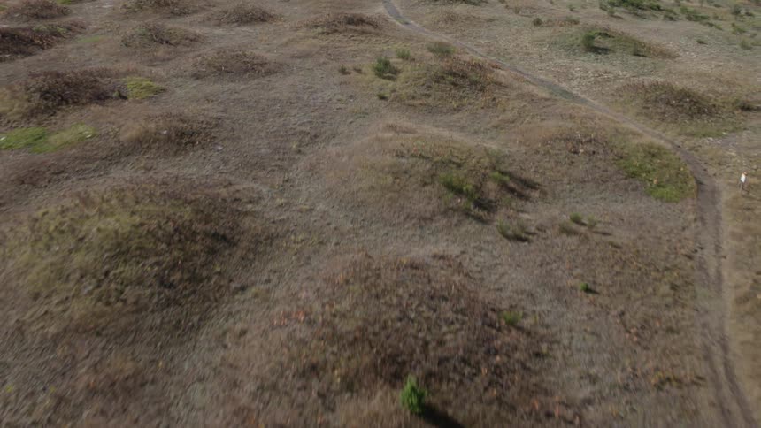 Flying along a hiking path that winds through many small hills