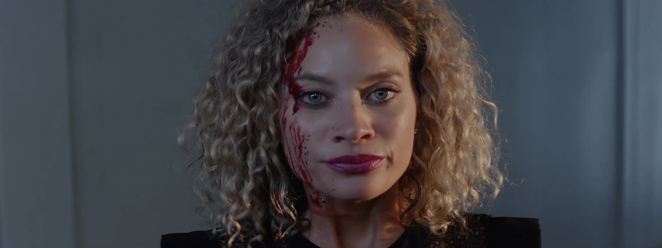 A woman breathes heavily while bleeding from her forehead