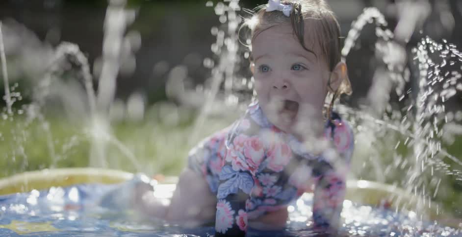 A child is playing in the water of a pool
