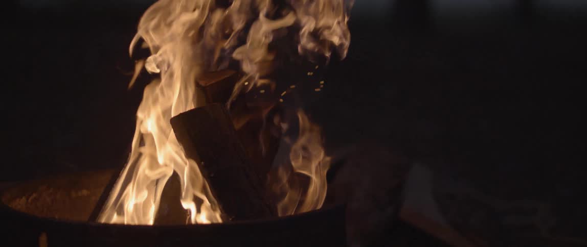 A camp fire burns at night