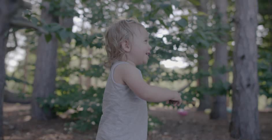 A toddler walks through the woods