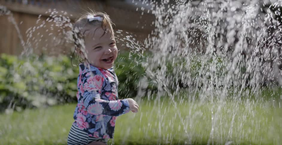 A toddler plays on a water toy