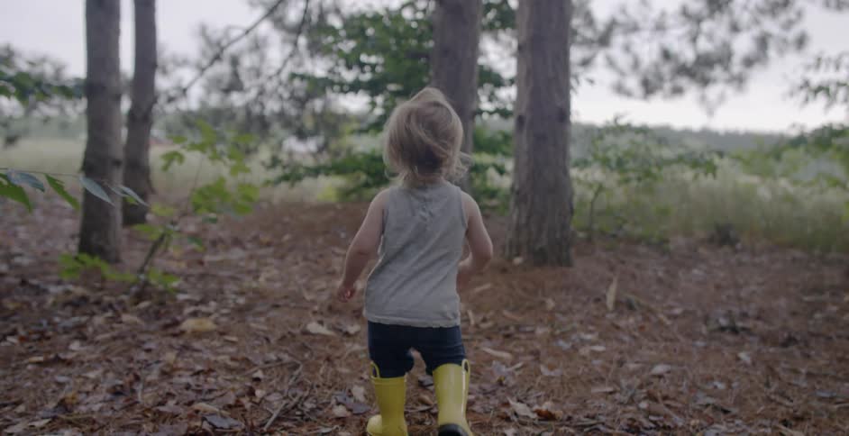 A young child plays out in nature