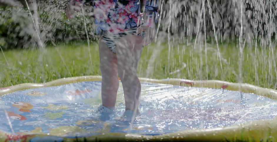 A child is playing in the pool fountain