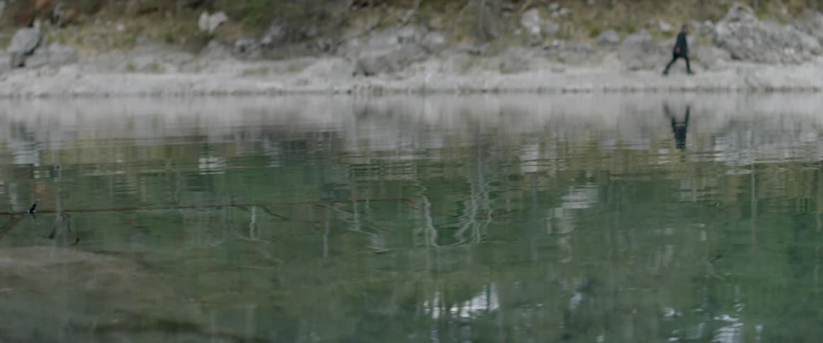 A man walks beside the water