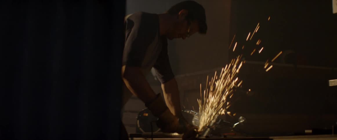 A man is using a tool to cut metal