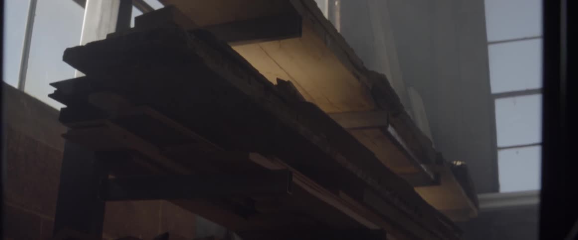 The boards of wood are on the high shelf
