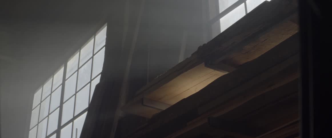 A light shines beneath a wood floor