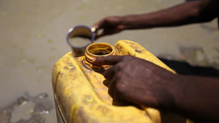 A person pouring liquid into a container