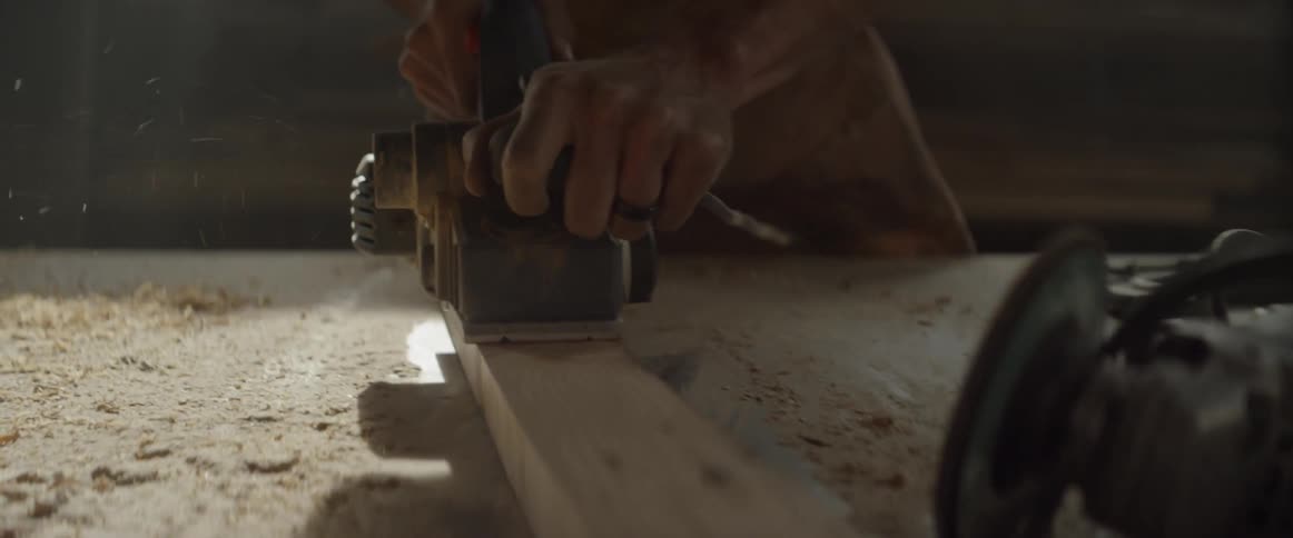 A man is sanding wood with a sander