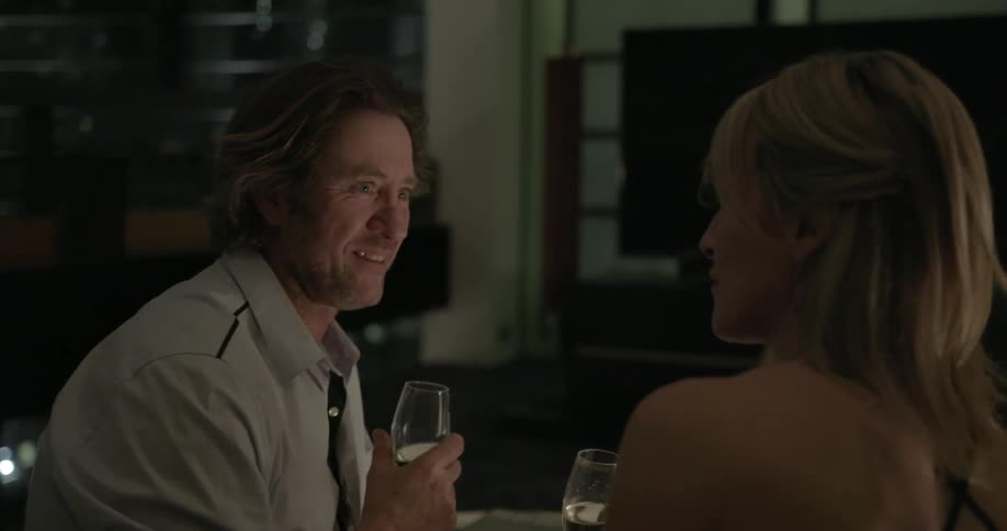 Man and woman drink wine at a dinner table