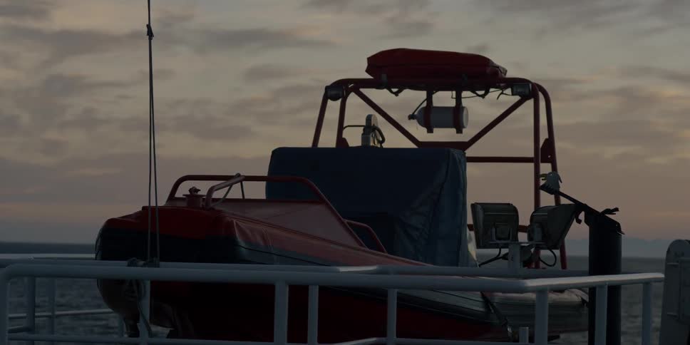 A lifeboat hangs from ropes on a large boat