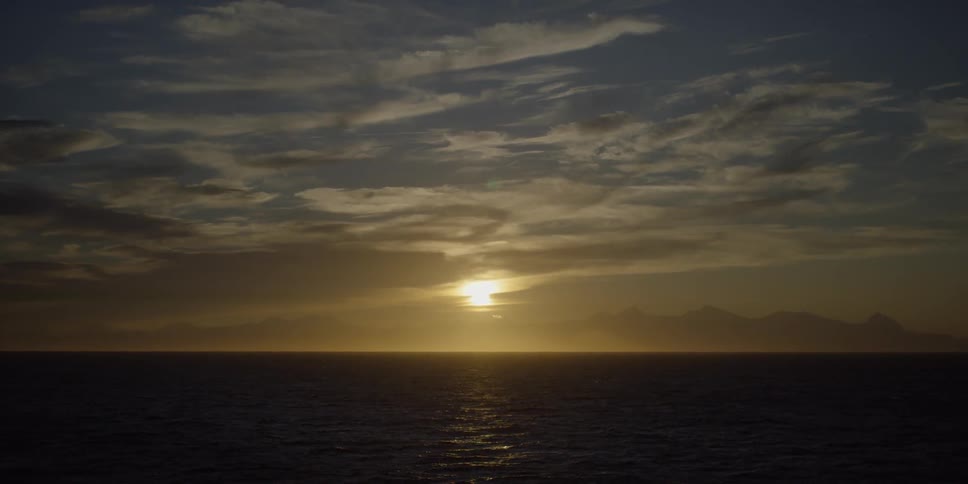 The sun is setting over the water ahead