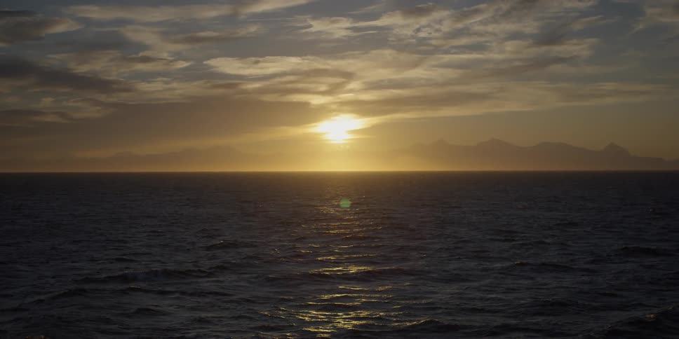 Ocean waves shimmer as the sun sets