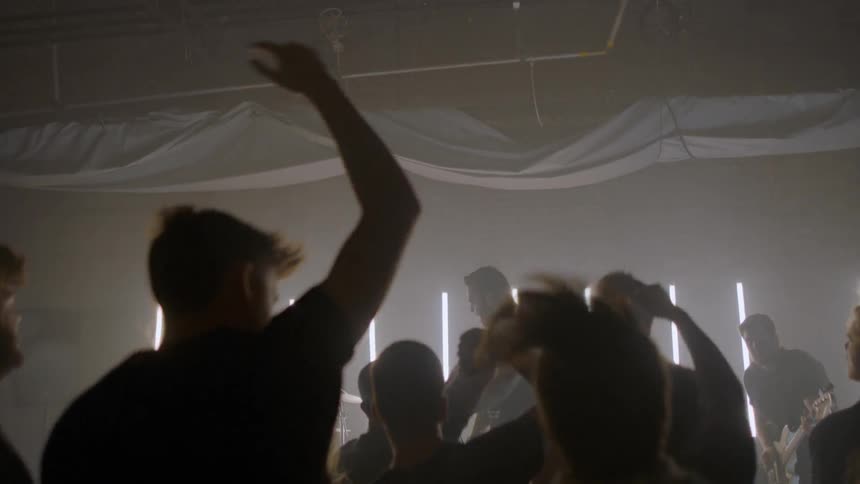 People jump up and down as they dance in a mosh pit