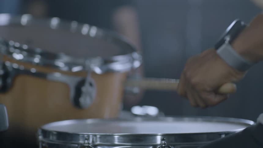 A drummer hits a snare drum