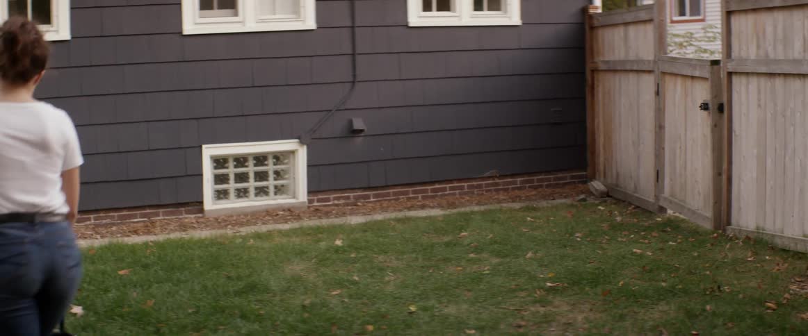 A woman mows the grass with a push mower